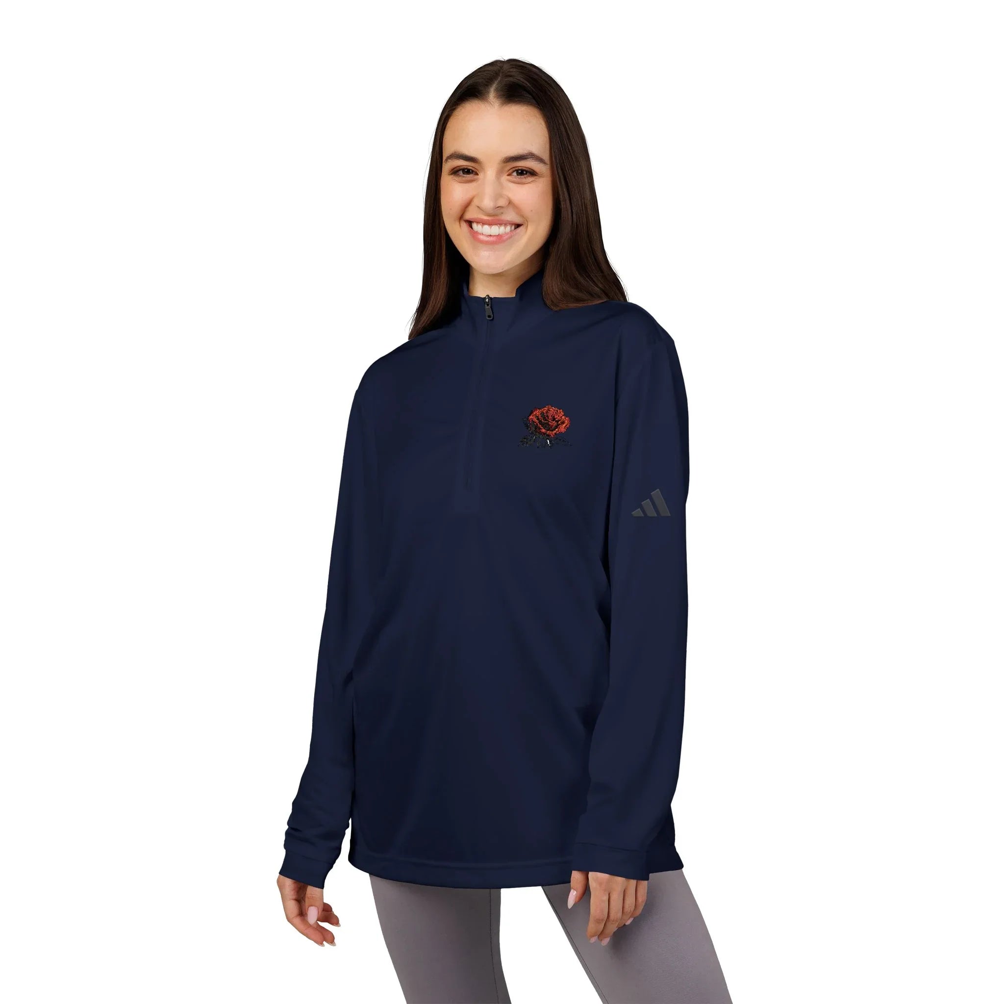 Woman wearing navy quarter-zip pullover with red rose embroidery and gray leggings