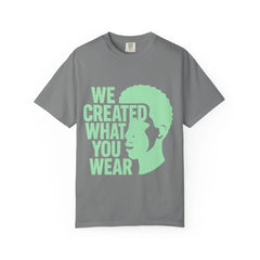 Gray t-shirt with green 'We Created What You Wear' text and silhouette design
