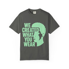 Dark gray t-shirt with green text 'WE CREATED WHAT YOU WEAR' and silhouette design