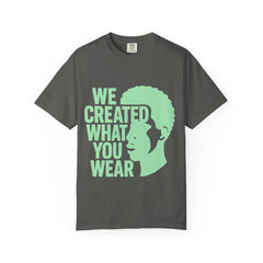 Dark gray t-shirt with green text 'WE CREATED WHAT YOU WEAR' and silhouette design