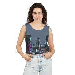 Woman in sleeveless top with neon cityscape print and light jeans, white background