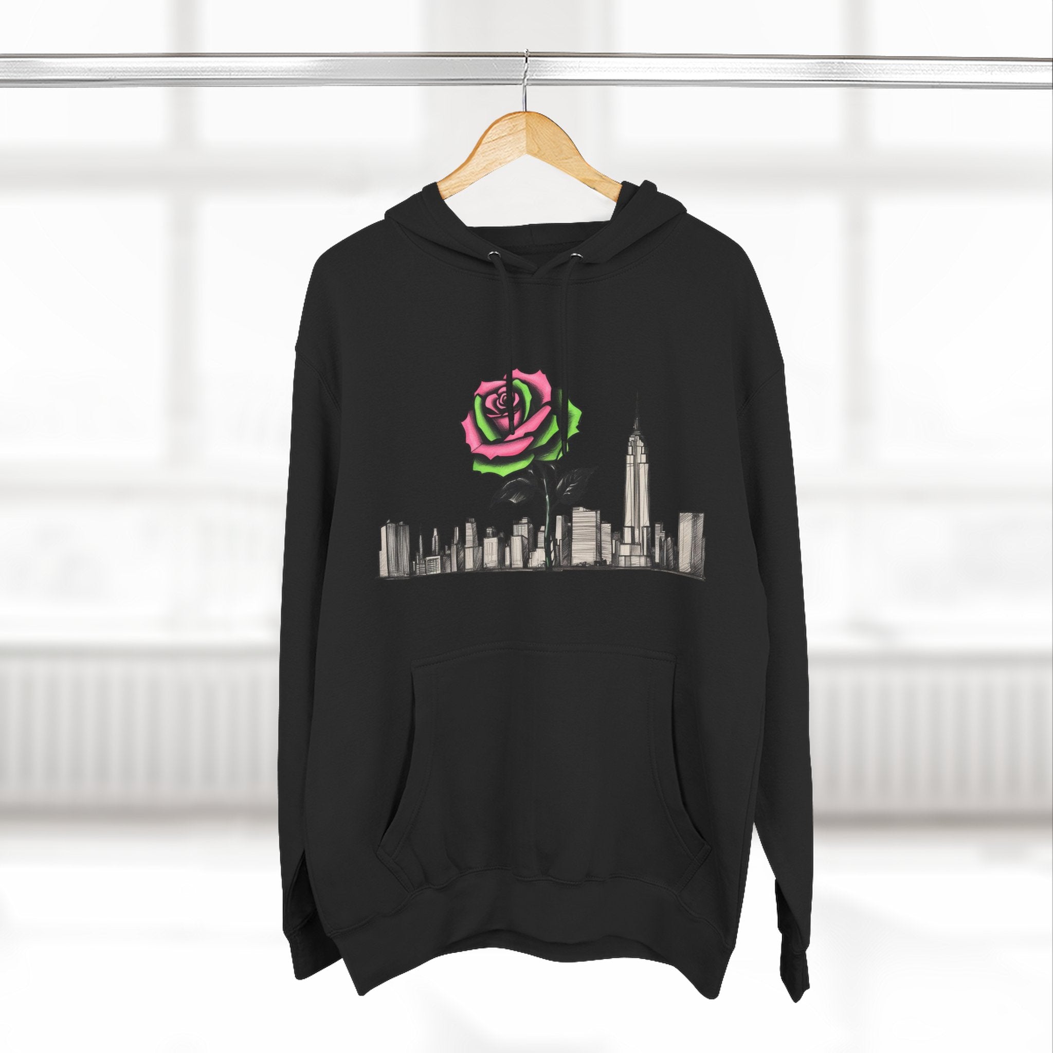 Black hoodie with pink and green rose graphic over city skyline, barcode detail on sleeve