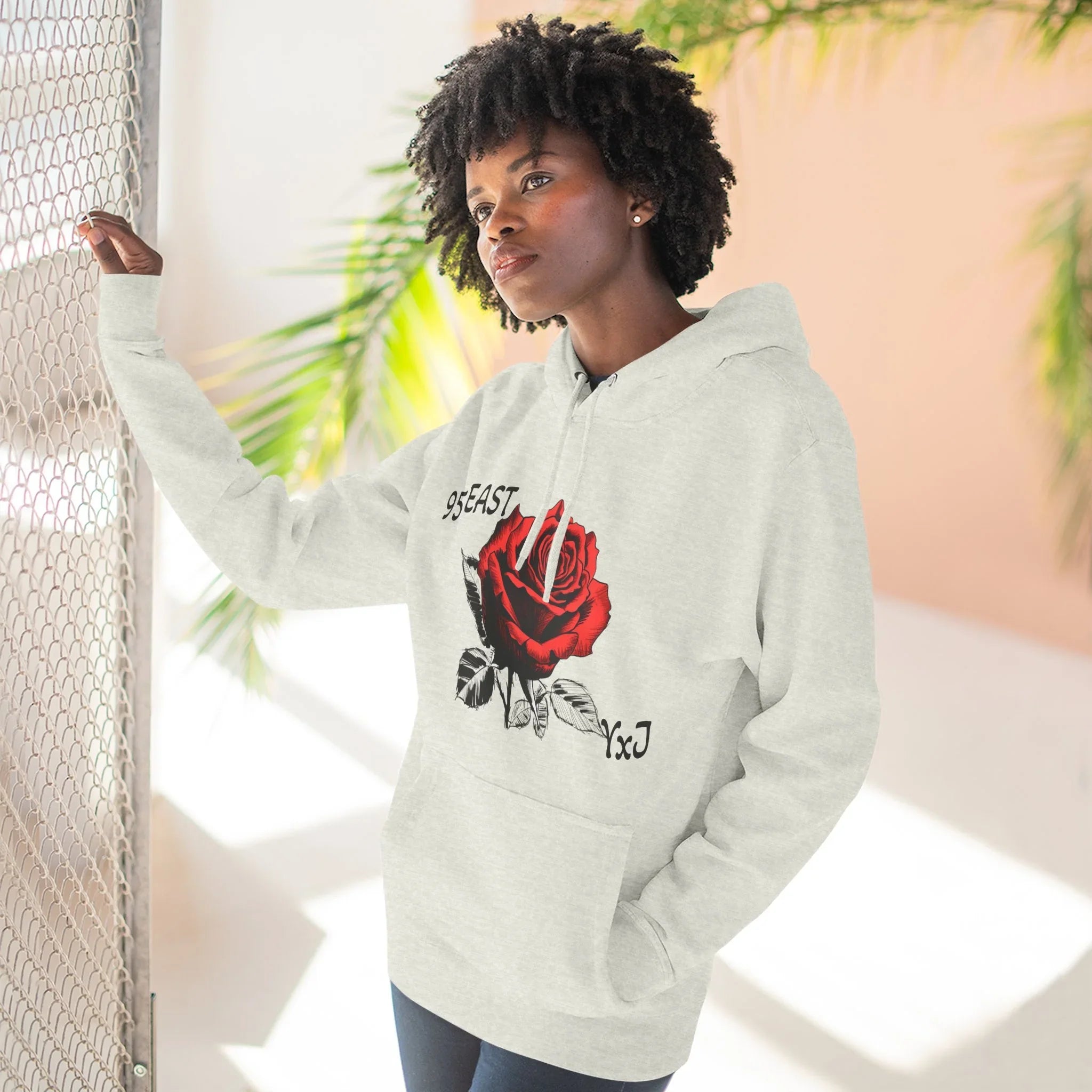 Black hoodie with red rose graphic and barcode sleeve detail, East Coast style