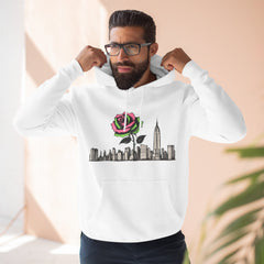 White hoodie with rose graphic over city skyline, worn by man adjusting hood