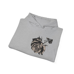 Gray hoodie with black and beige rose graphic design on front, folded on white background