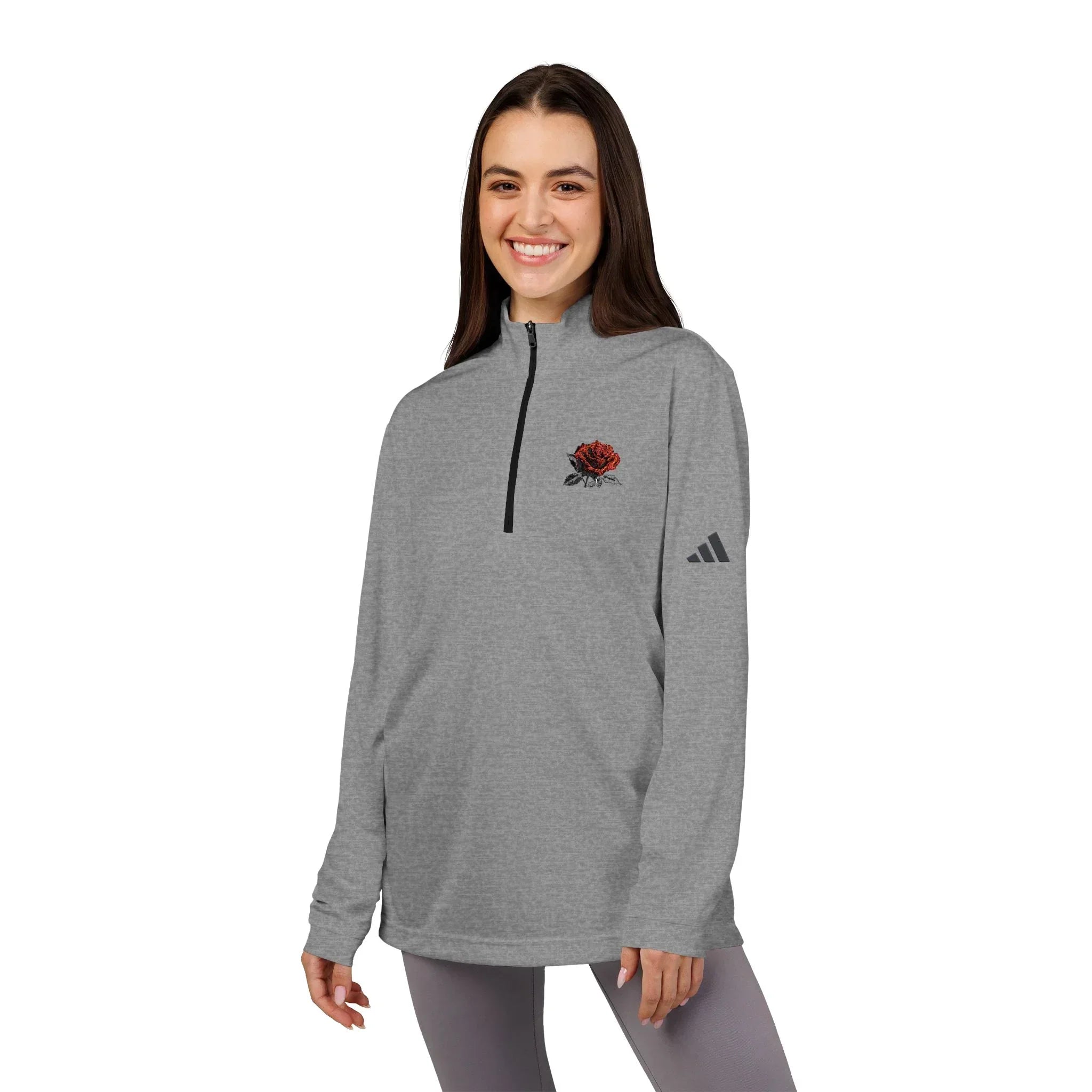 Woman wearing gray quarter-zip pullover with red rose graphic and athletic logo, casual outfit