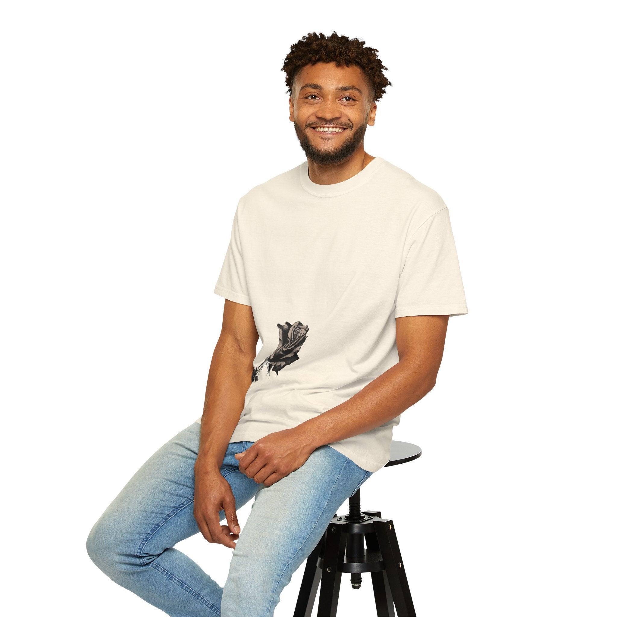 Man wearing white t-shirt with black rose graphic, sitting on stool, casual style