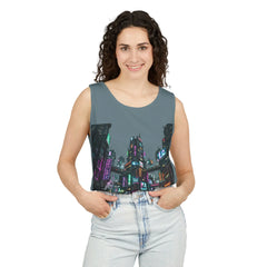 Woman wearing a sleeveless top with a neon cityscape print, hands in pockets, white background.