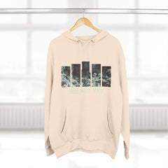 Beige hoodie with abstract graphic bars and '95EAST YXJ' text, hanging indoors.