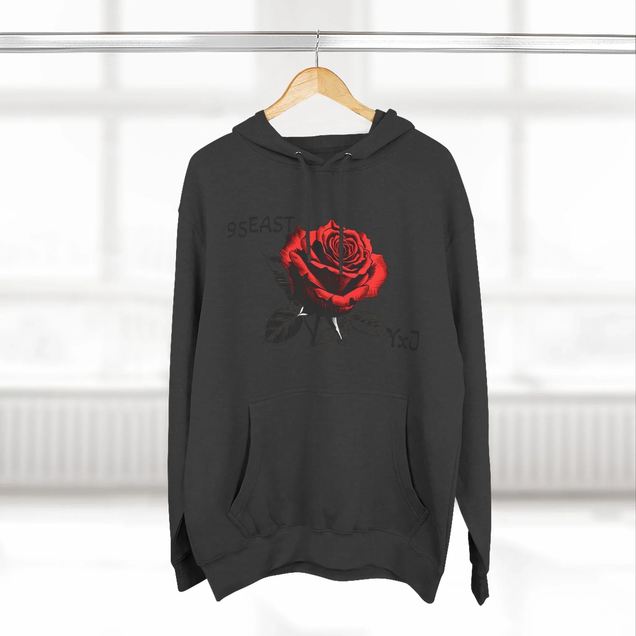 Black hoodie with red rose graphic and barcode sleeve detail, modern streetwear design