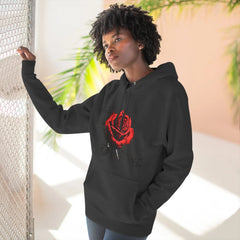 Black hoodie with red rose graphic and barcode sleeve detail, worn by woman near mesh fence