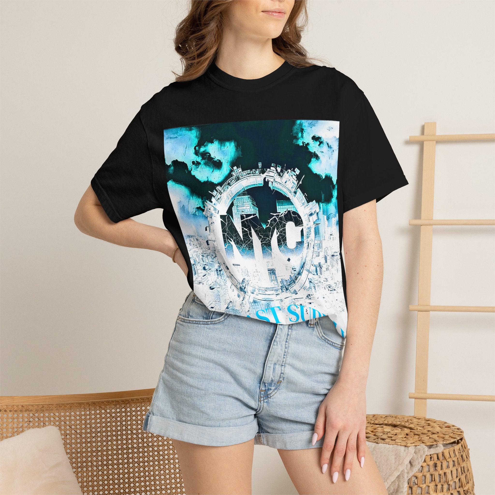 Black graphic tee with NYC cityscape print, blue sky design, and East Side text, paired with denim shorts.