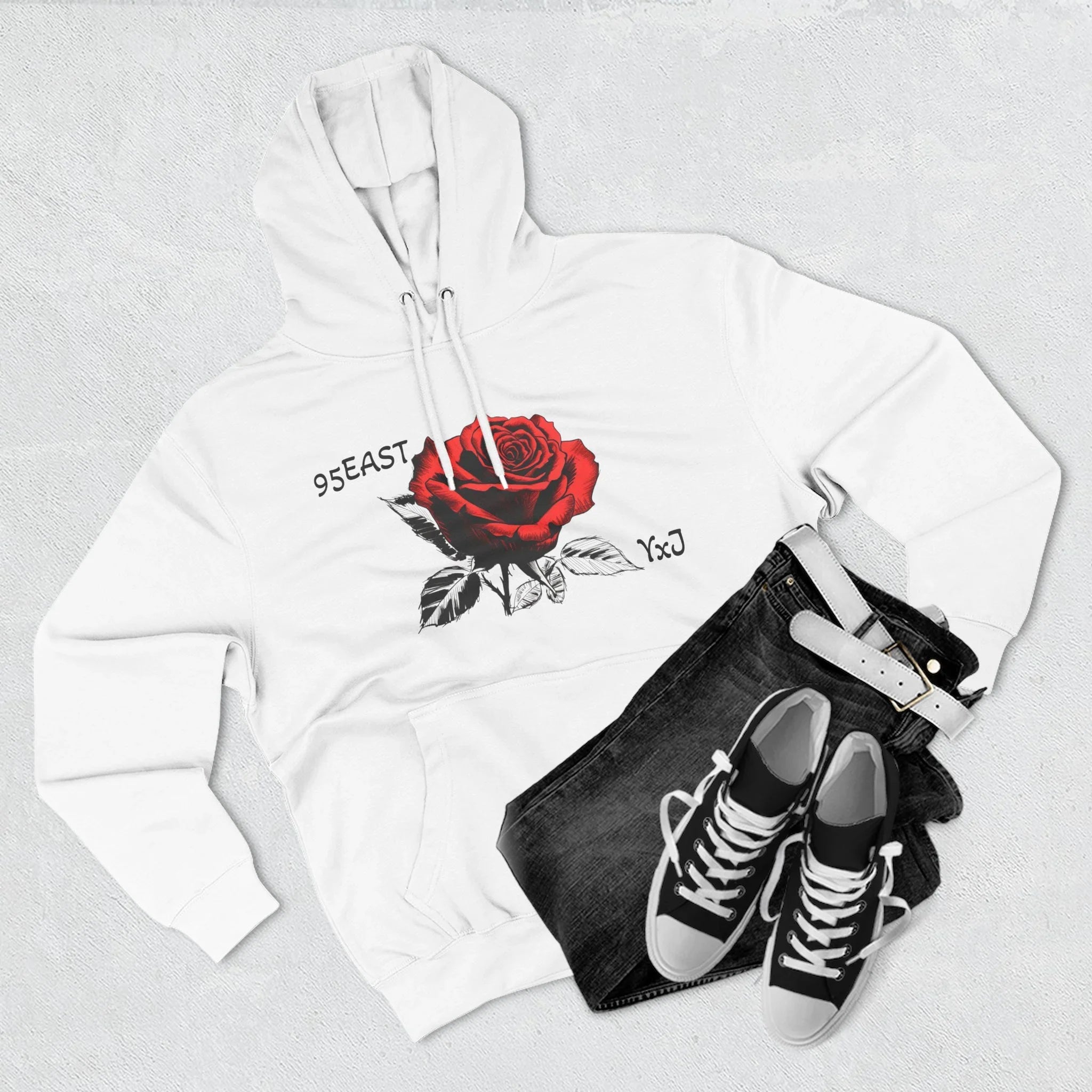 White hoodie with red rose graphic and 95EAST YxJ text, styled with black jeans and sneakers