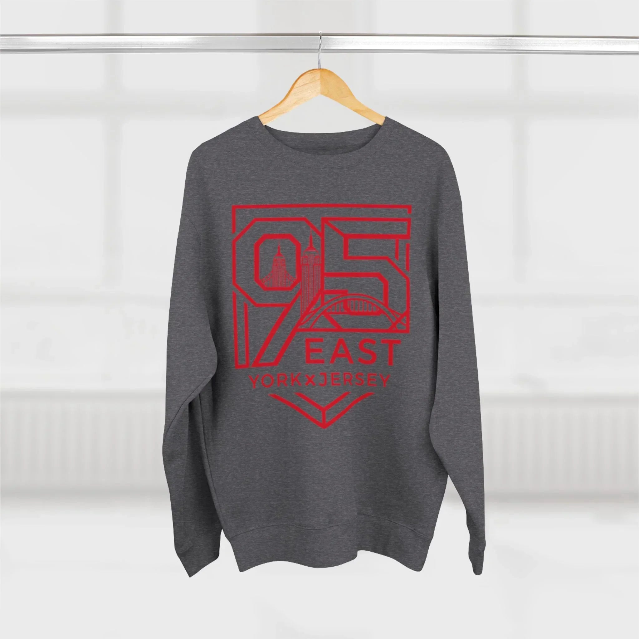Gray hoodie with red 95 East YorkxJersey graphic, hanging on wood hanger