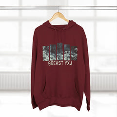 Maroon hoodie with graphic print and 95EAST YXJ text on hanger in bright room