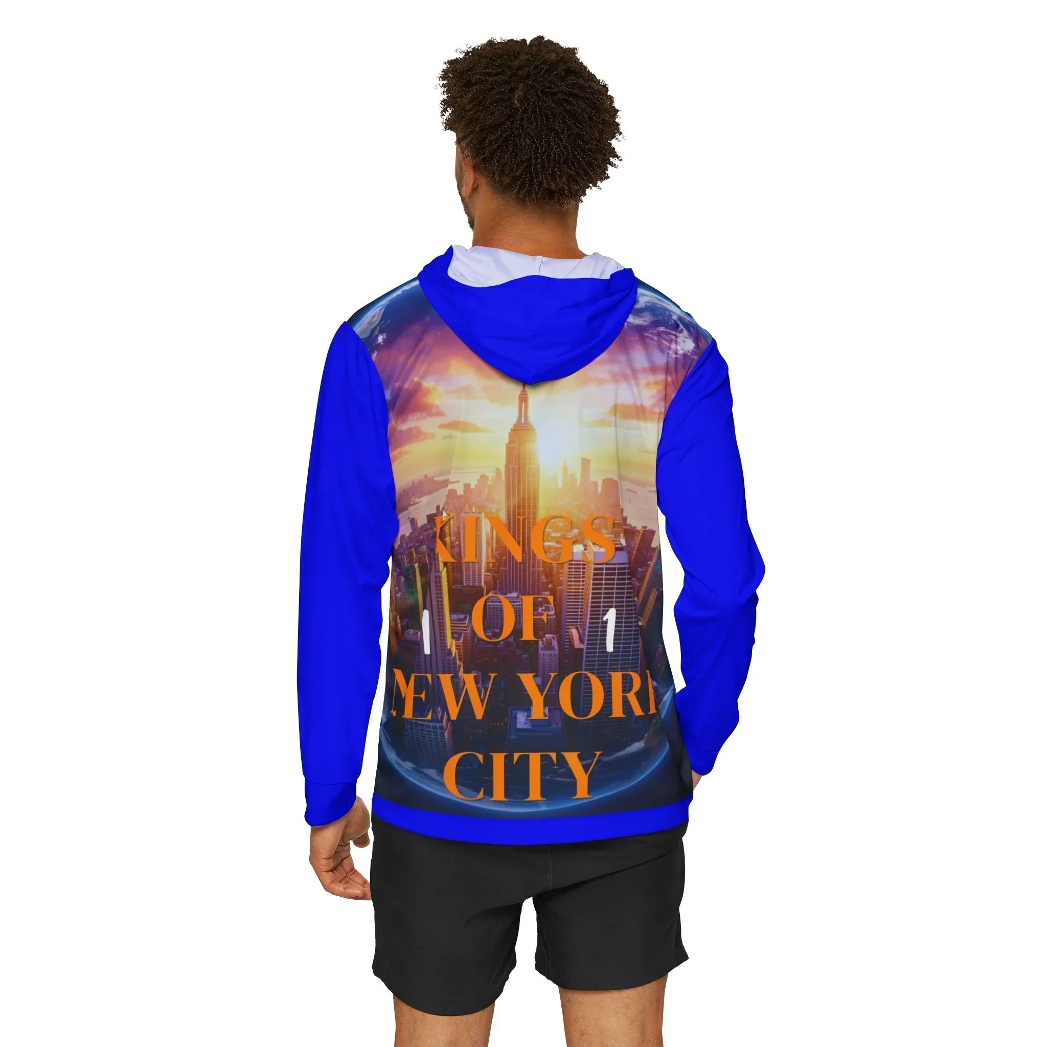 Man wearing blue hoodie with 'Kings of New York City' graphic, NYC skyline sunset design, East Coast streetwear style