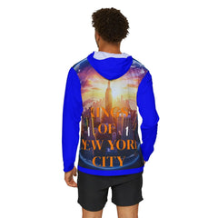 Man wearing blue hoodie with 'Kings of New York City' graphic, NYC skyline sunset design, East Coast streetwear style