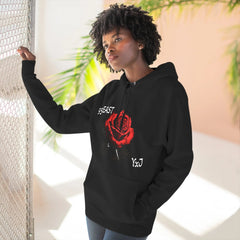 Black hoodie with red rose graphic and barcode sleeve detail, worn by woman near chain-link fence