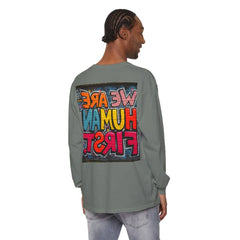 Man wearing a gray long sleeve shirt with colorful graffiti text 'We Are Human First' on back