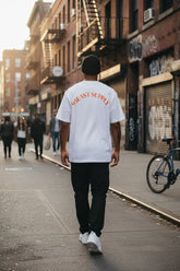 Man wearing white 95EAST SUPPLY tee walking urban street, East Coast lifestyle fashion