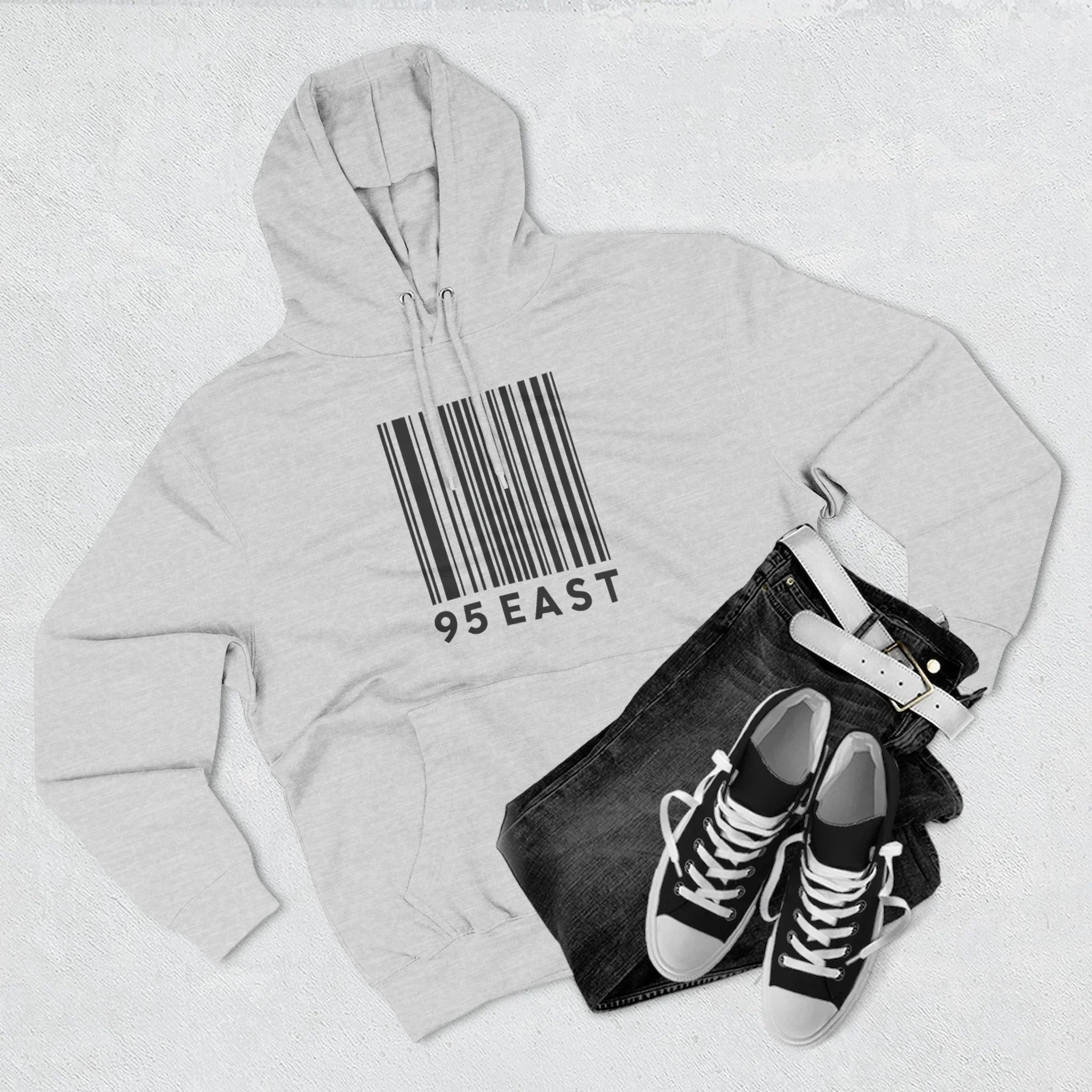 Gray hoodie with barcode design and '95 EAST' text, paired with black jeans and sneakers.