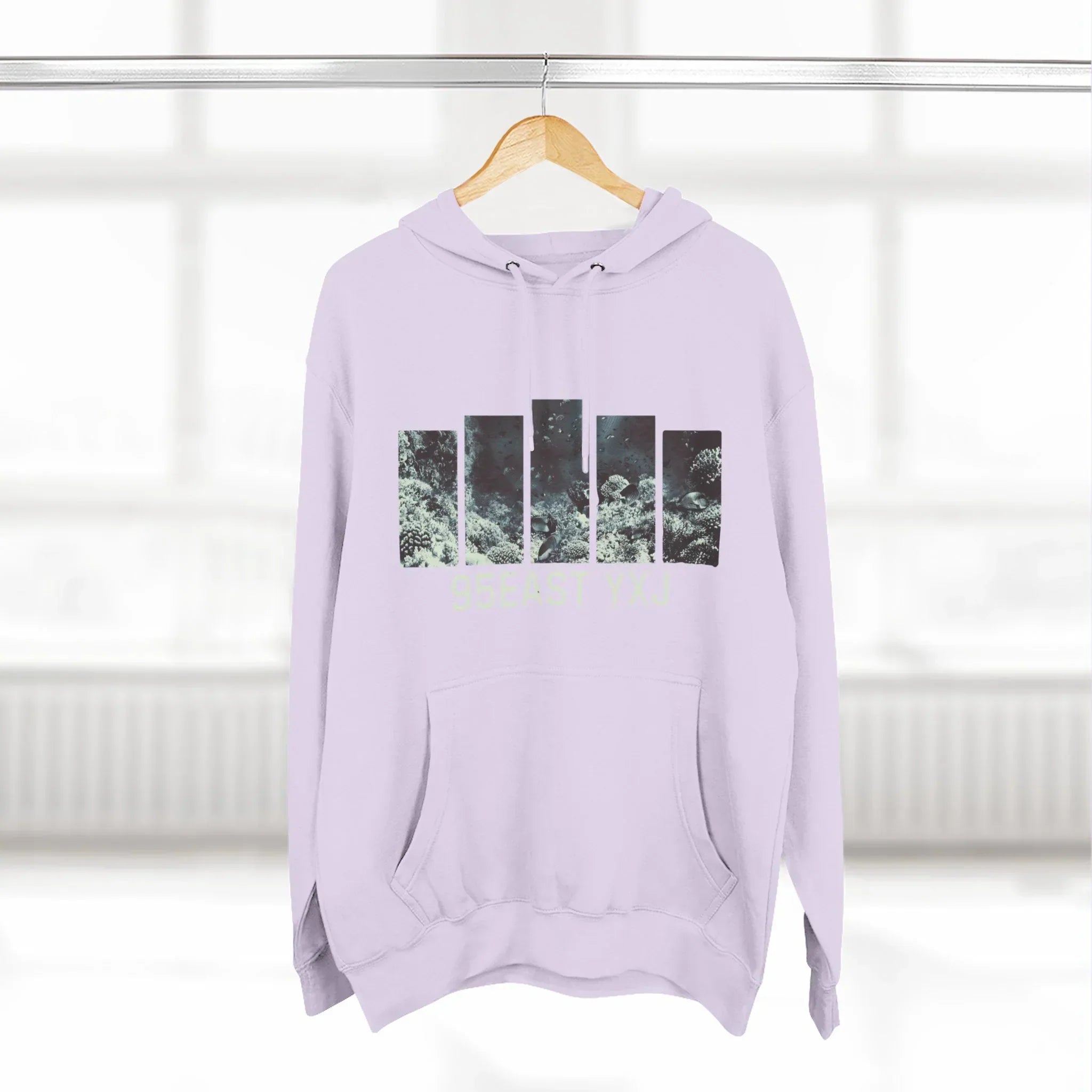 Light purple hoodie with abstract nature graphic bars and front pocket, displayed on hanger