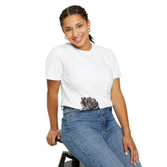 Woman wearing white t-shirt with black rose graphic, paired with blue jeans, smiling confidently.