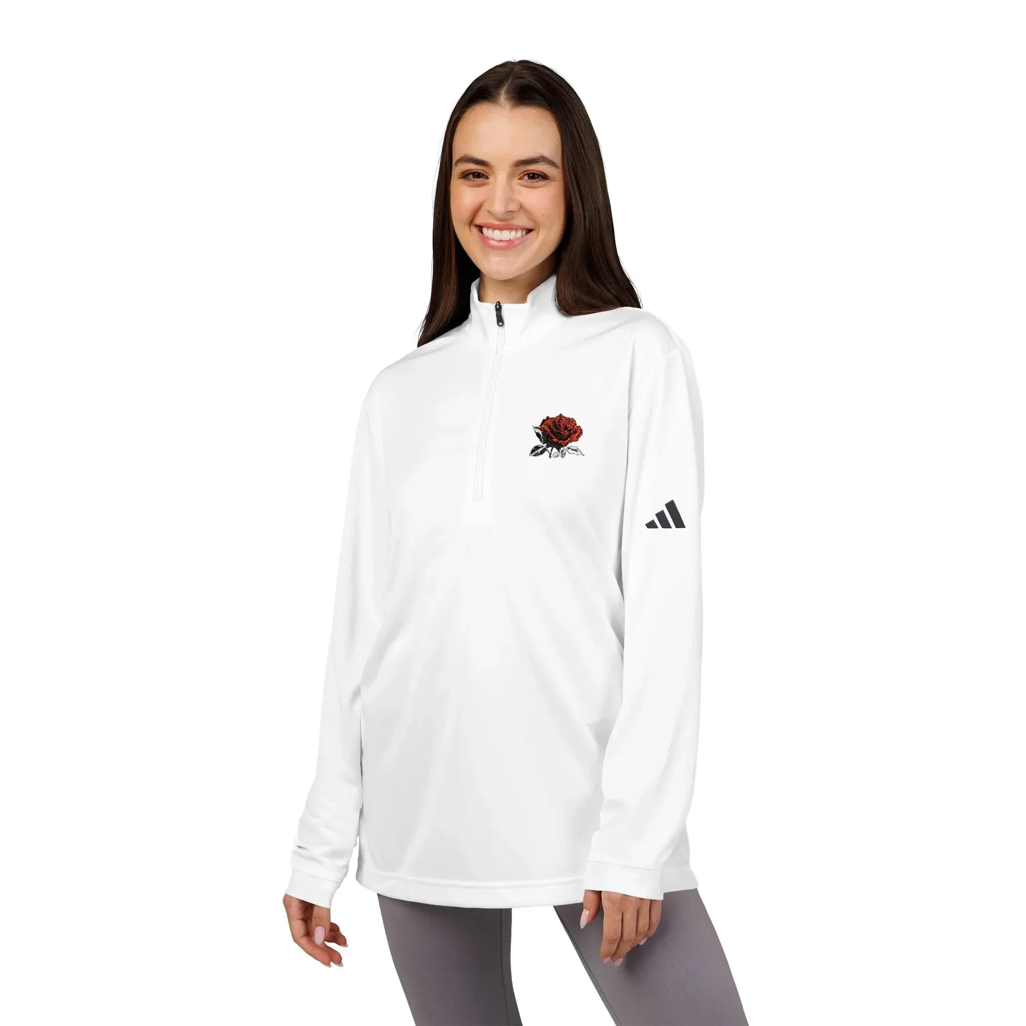 Smiling woman wearing a white quarter-zip pullover with red rose embroidery and black logo sleeve detail