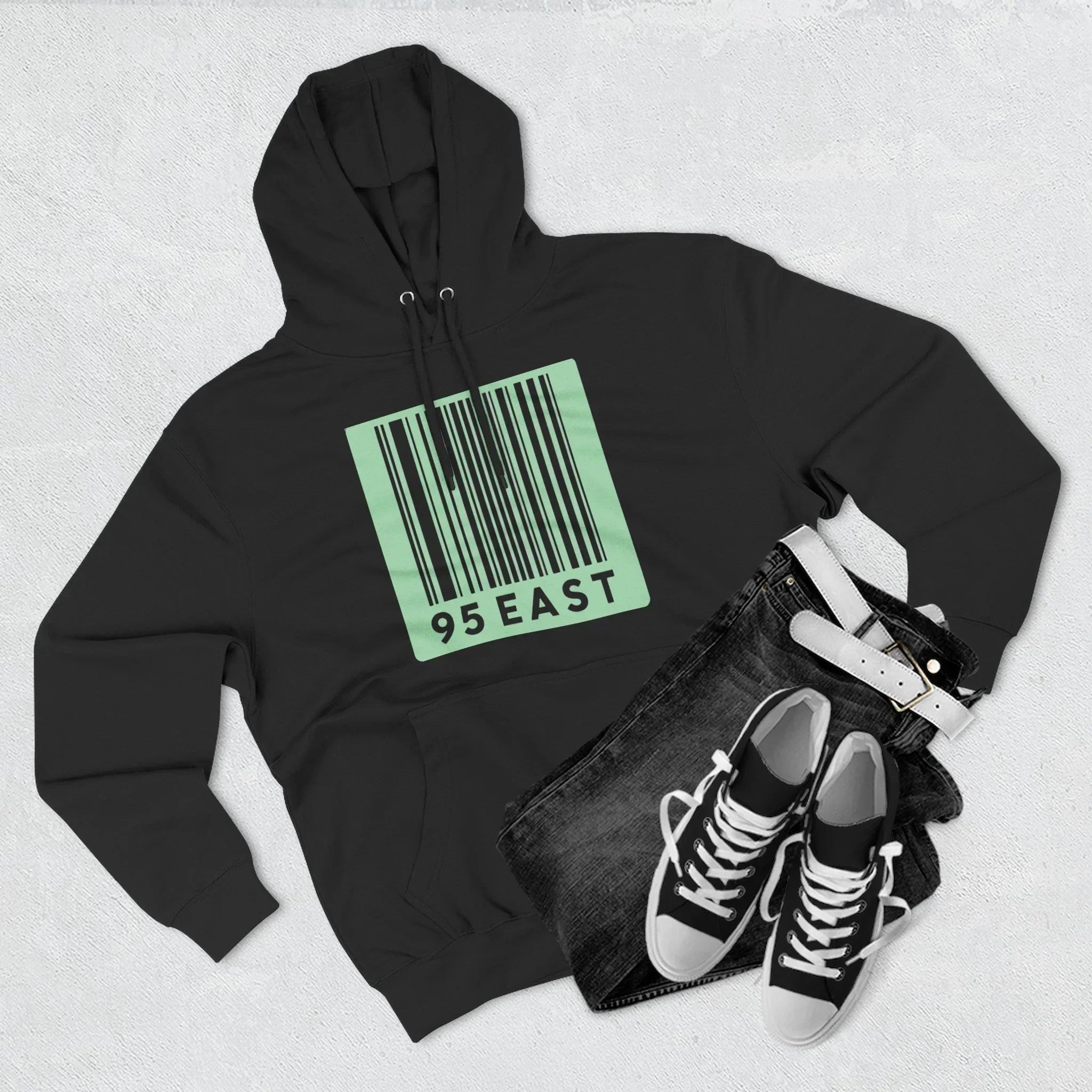 Black hoodie with green barcode design, paired with jeans and sneakers for casual streetwear style.