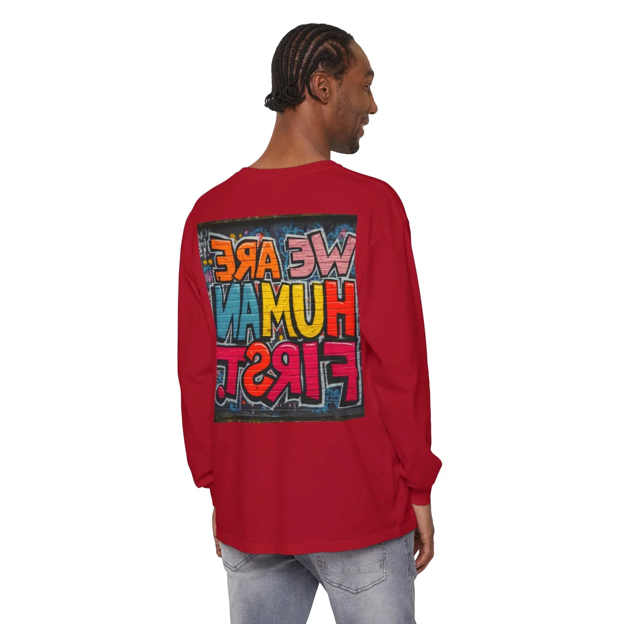Man wearing red long-sleeve shirt with colorful graffiti-style 'WE ARE HUMAN FIRST' text on back