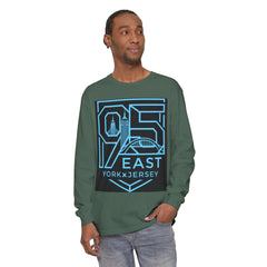 Man wearing olive green long sleeve tee with bold 95 East York x Jersey graphic, featuring city skyline design.