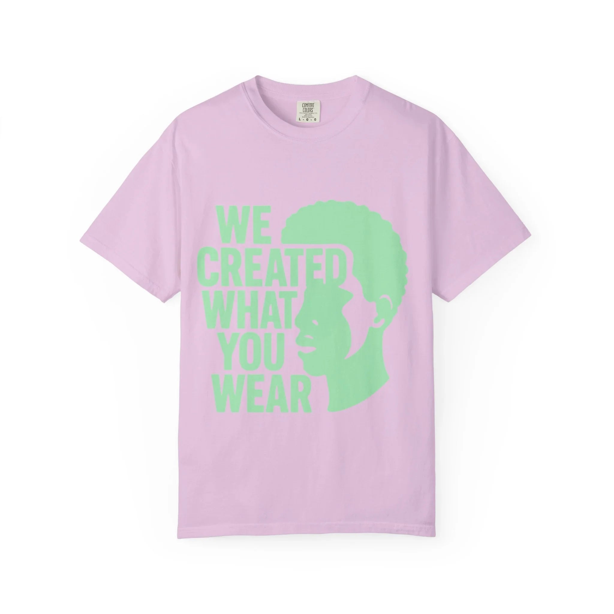 Pink t-shirt with green 'We Created What You Wear' text and silhouette design