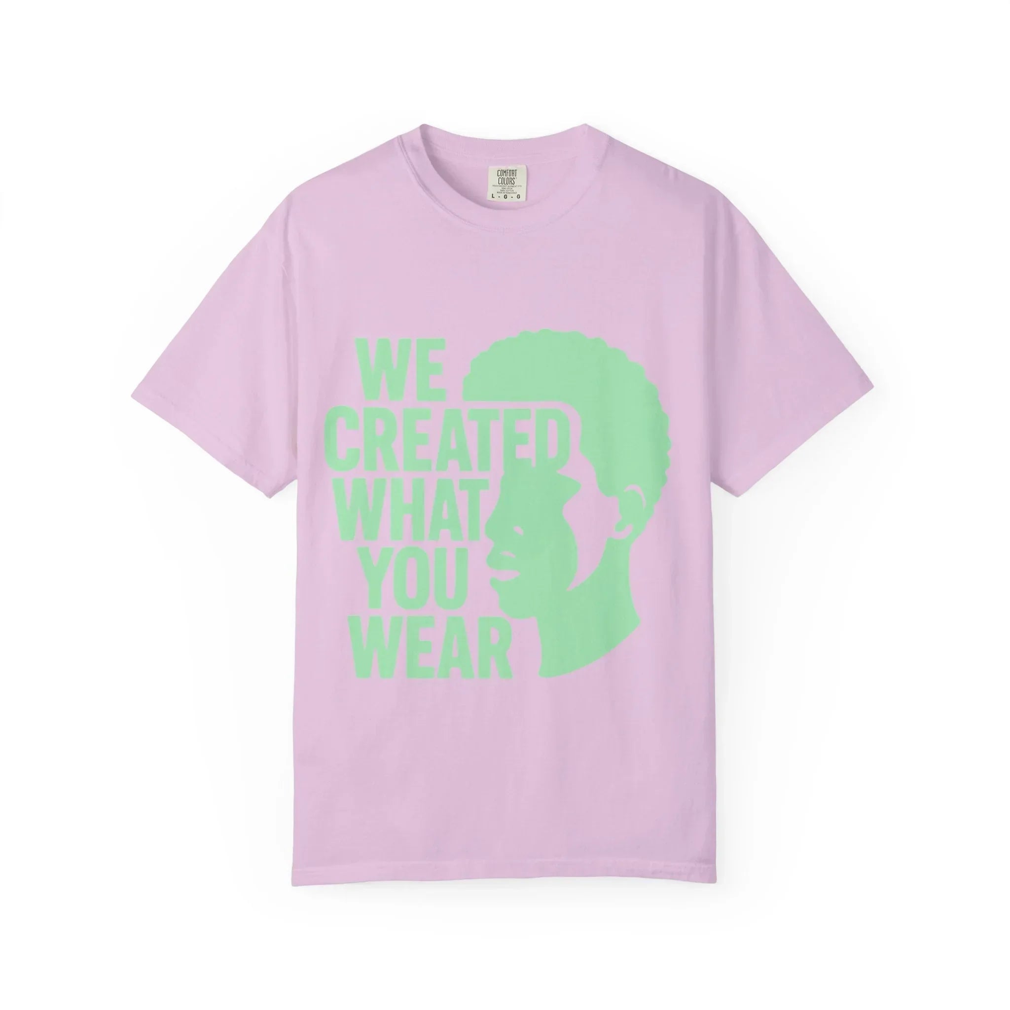 Pink t-shirt with green 'We Created What You Wear' text and silhouette design