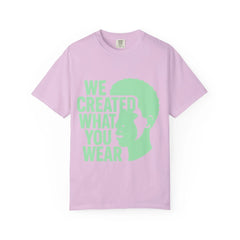 Pink t-shirt with green 'We Created What You Wear' text and silhouette design