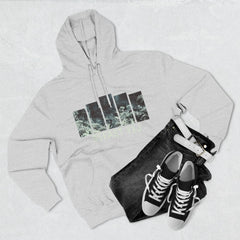 Light gray hoodie with graphic design, black jeans, white belt, and black sneakers laid flat