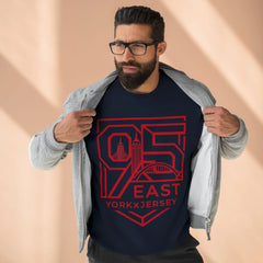 Man wearing navy tee with red 95 East YorkxJersey graphic, layered under gray zip hoodie