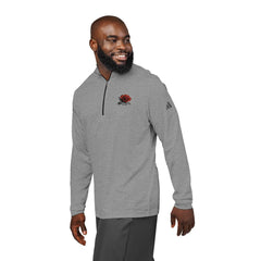 Man wearing gray quarter-zip pullover with embroidered red rose design on chest, isolated.