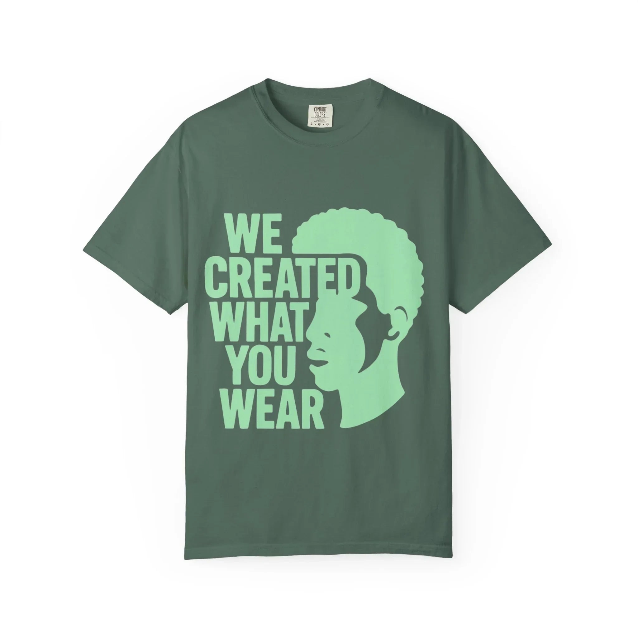 Green t-shirt with 'We Created What You Wear' text and silhouette design