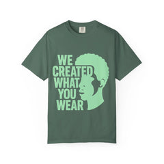 Green t-shirt with 'We Created What You Wear' text and silhouette design