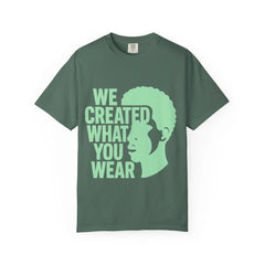 Green t-shirt with 'We Created What You Wear' text and silhouette design