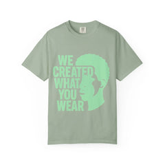 Green t-shirt with 'WE CREATED WHAT YOU WEAR' text and silhouette design