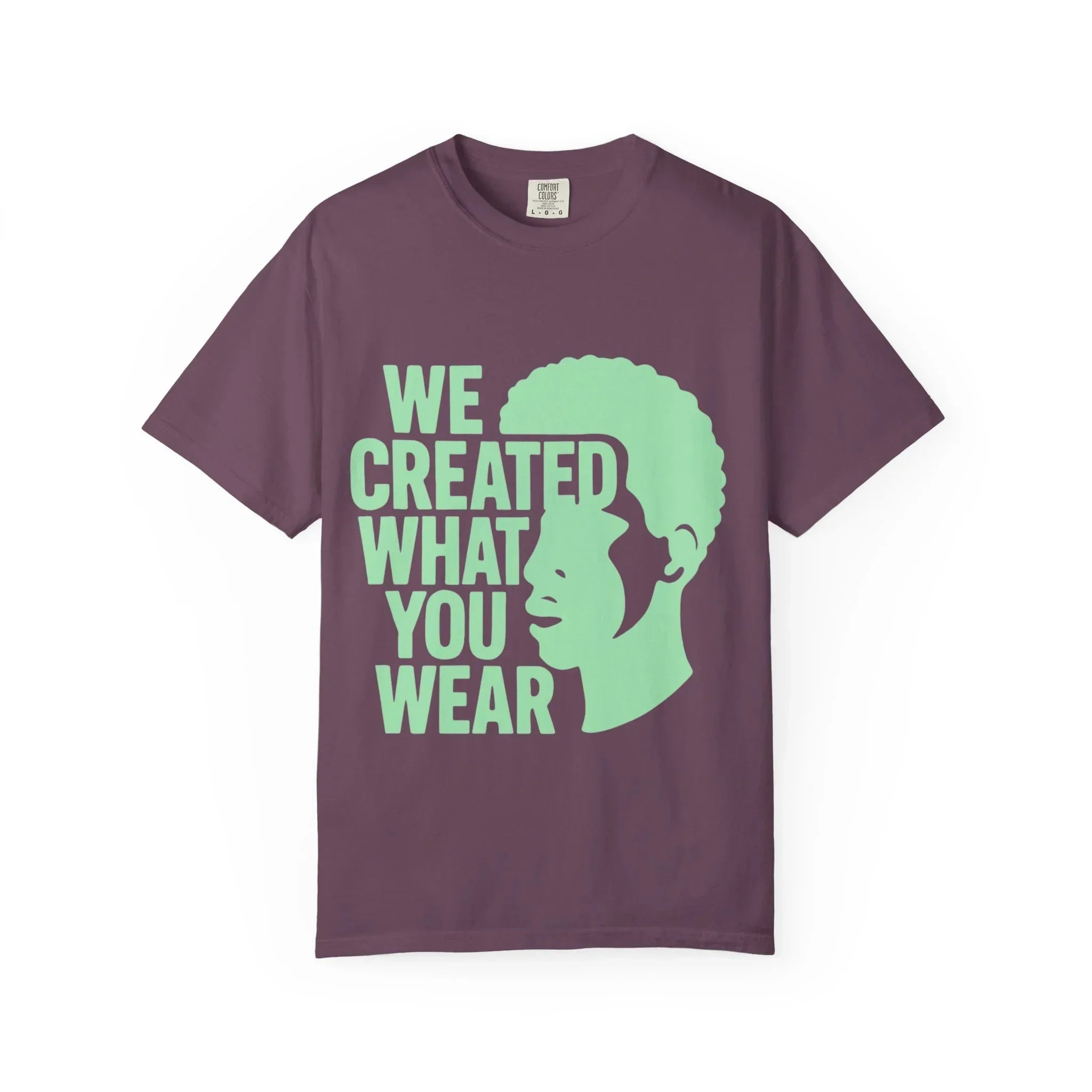 Purple t-shirt with green 'We Created What You Wear' text and silhouette graphic, lifestyle apparel design