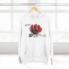 White hoodie with red rose graphic and 95EAST YxJ text, hanging on wood hanger