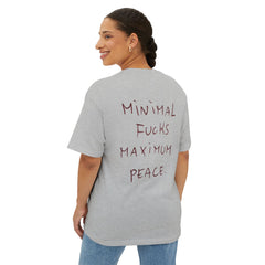 Gray oversized t-shirt with 'Minimal Fucks Maximum Peace' text on back, worn by woman in jeans