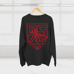 Black hoodie with bold red 95 East YorkxJersey graphic, featuring city skyline design, hanging on wooden hanger