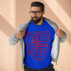 Man wearing blue 95 East YorkxJersey graphic tee with red skyline design, layered under gray hoodie