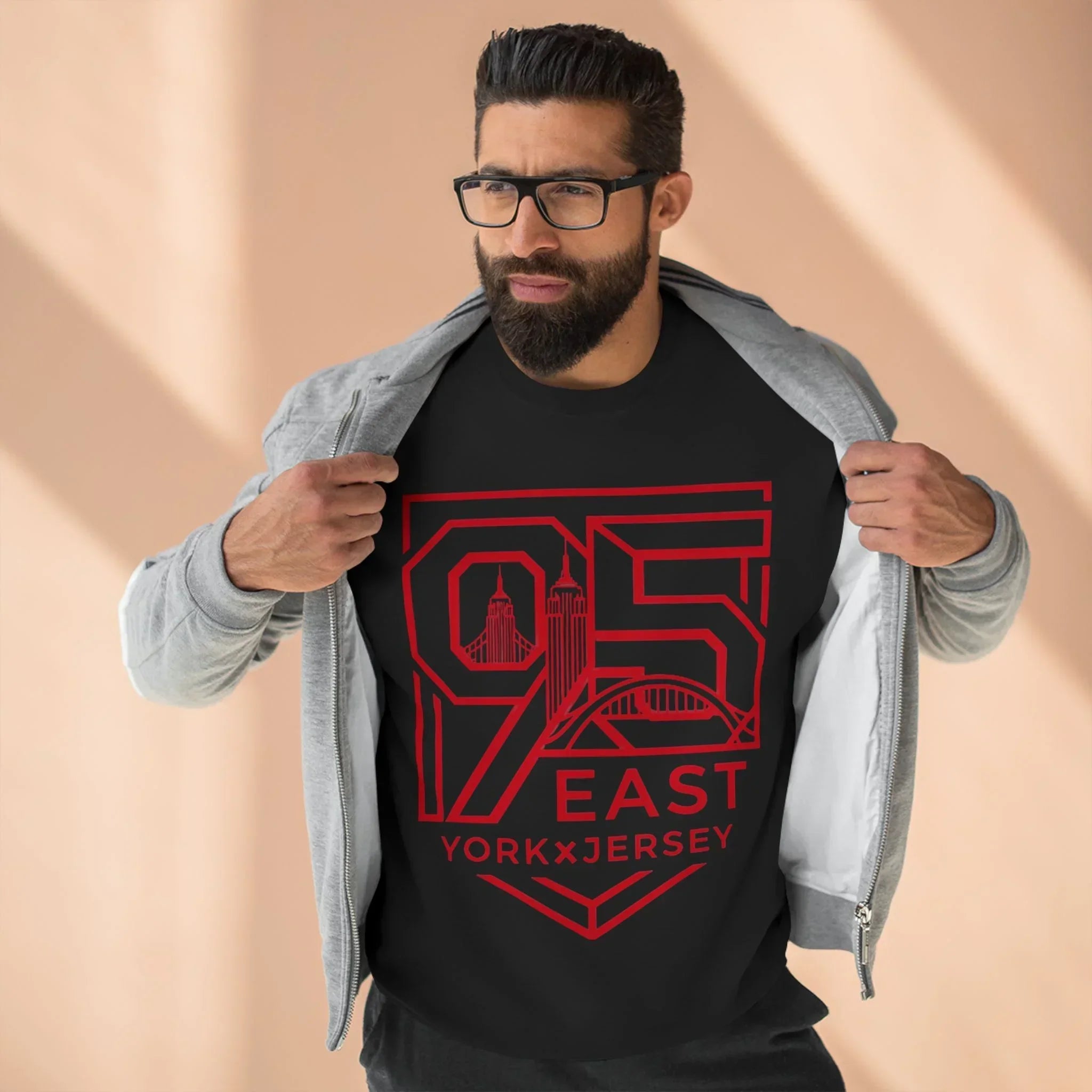 Black hoodie with red 95 East YorkxJersey graphic, worn under gray zip-up, showcasing urban design