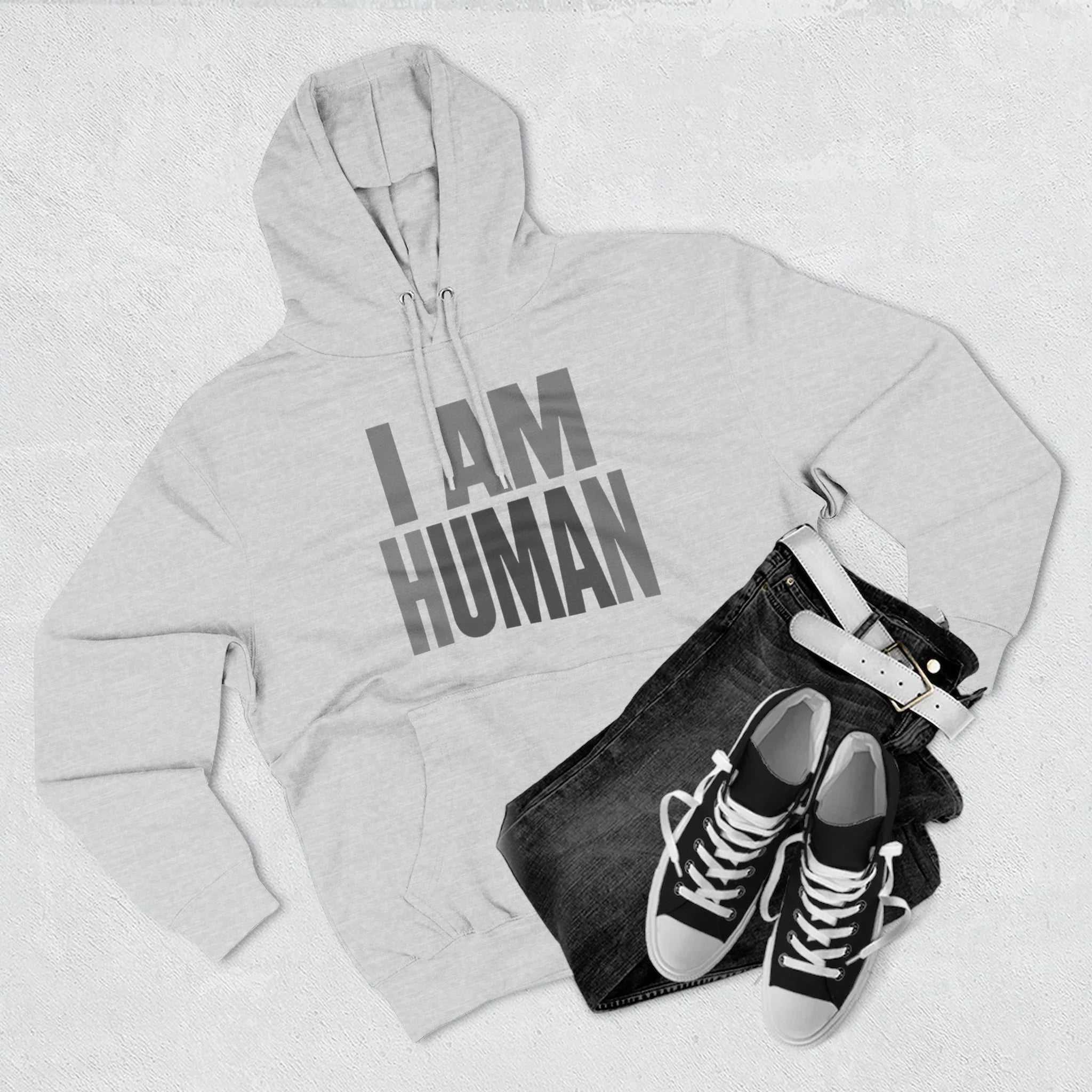 Gray hoodie with 'I AM HUMAN' text, paired with black jeans, white belt, and black sneakers