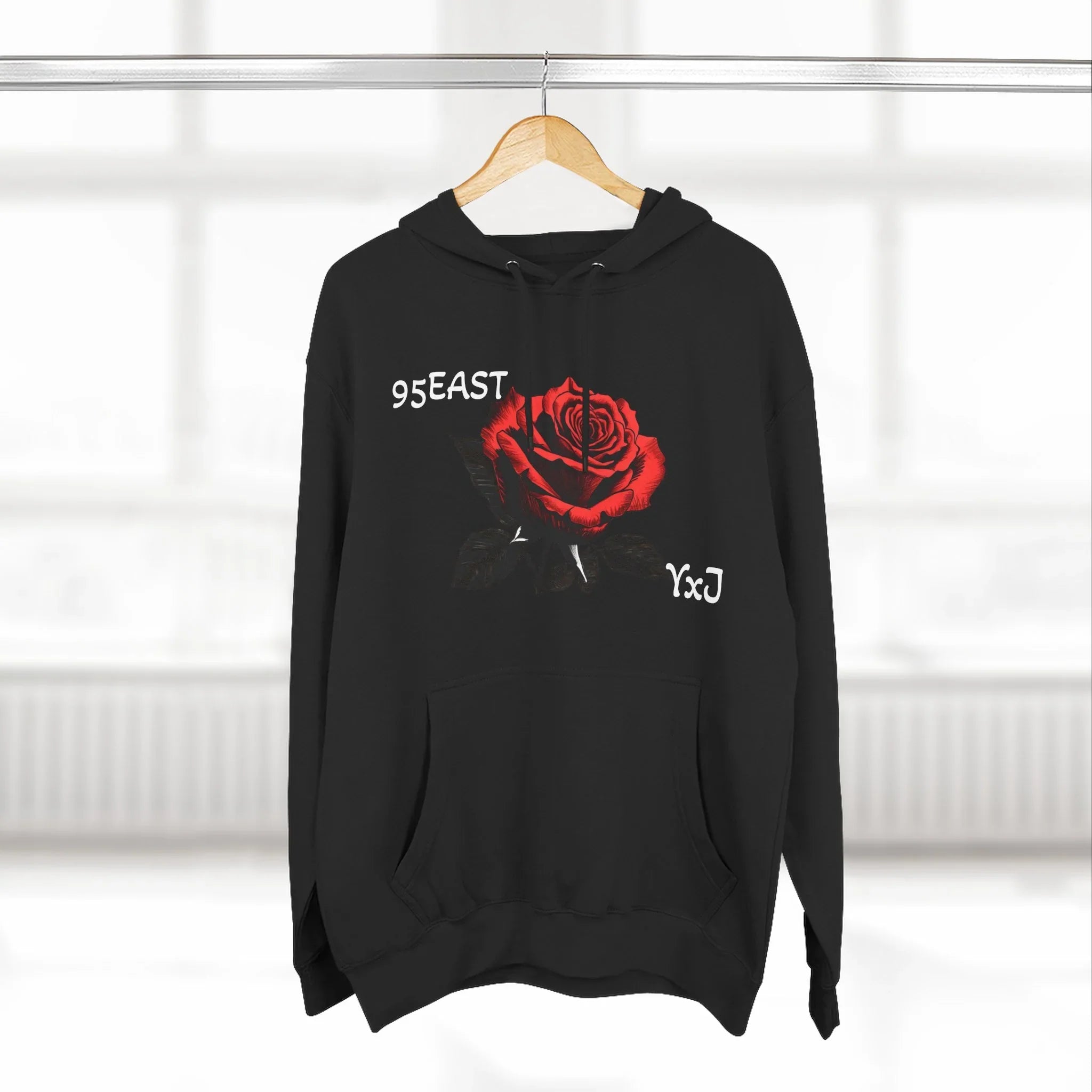 Black hoodie with red rose graphic and barcode sleeve detail, featuring 95EAST and YxJ text