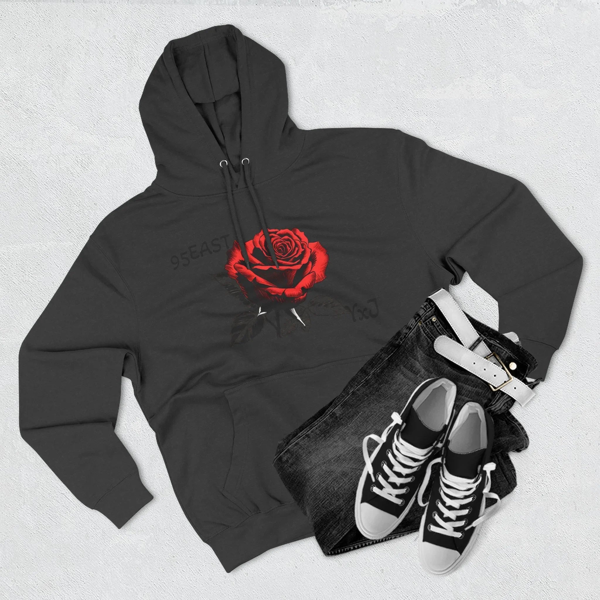 Black hoodie with red rose graphic and barcode sleeve detail, styled with jeans and sneakers